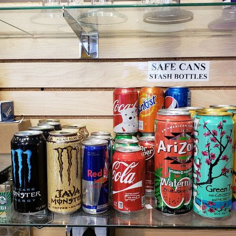A shelf displaying various cans of soda and other beverages.