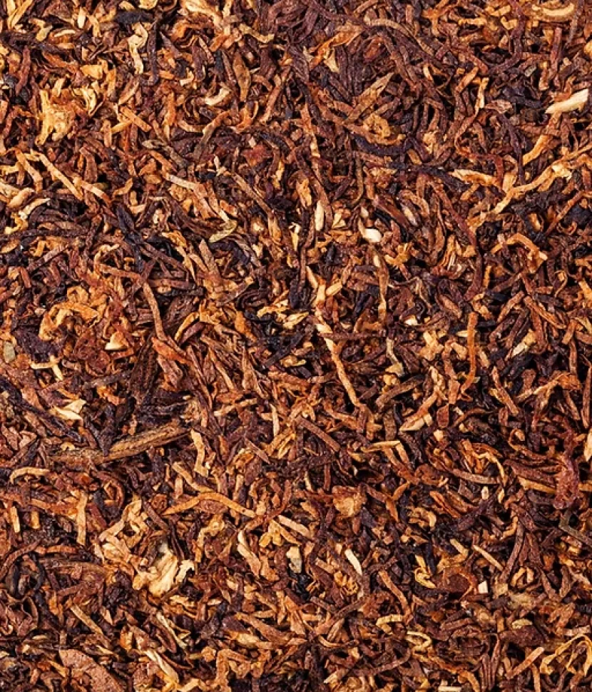 A close-up view of a pile of tobacco leaves, showcasing their texture and color variations.
